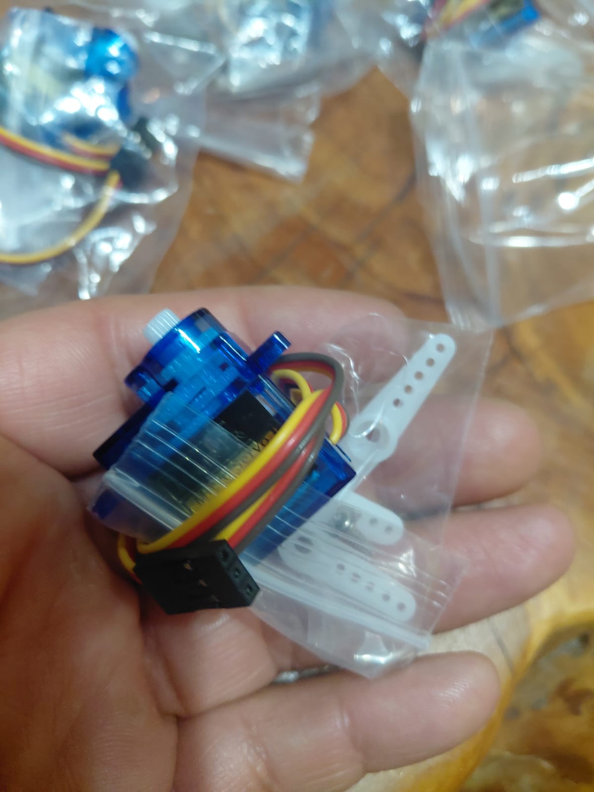 Close-up of the SG90 servo connector showing the three-pin female header with red (VCC), brown (GND) and yellow (signal) wires